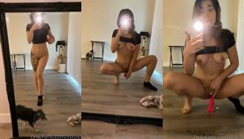 Uma influencer registrando um vídeo no espelho fazendo poses sensuais com seu brinquedo erótico