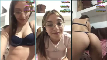 Garota nova com óculos fazendo um striptease durante a transmissão ao vivo