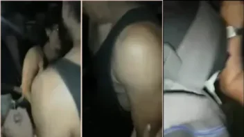 Uma gata na rua fazendo um programa com um cara na frente de um monte de gente